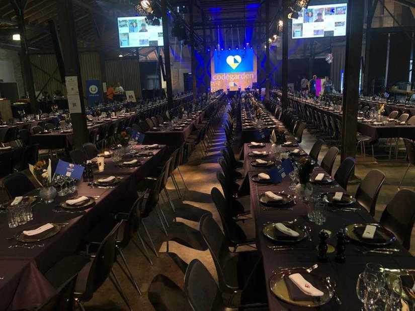 A picture of a conference hall filled with banquet-style seating.