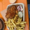 French fries, fried chicken, cucumber, coleslaw and dipping sauce in a carboard tray
