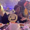 Three attendees with a the top part of a wedding cake and the Umbraco logo planted on top