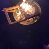 A wooden beach chair burning in a fire pit